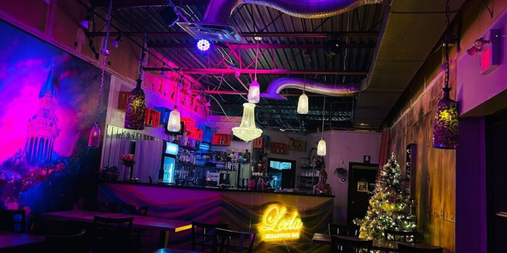 A bar with purple and blue lights, creating a vibrant and colorful atmosphere.