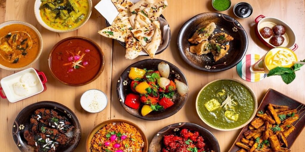 A variety of food items displayed on a table, including fruits, vegetables, meats, and desserts.