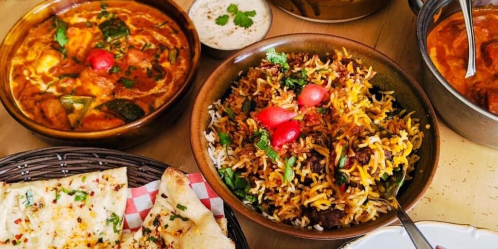 A beautifully presented spread of Indian food in bowls on a table at Leela Indian Food Bar.