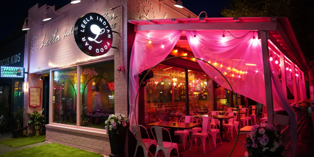 Leela Indian Food Bar's cozy setting featuring pink lights and a curtain, enhancing the dining experience.