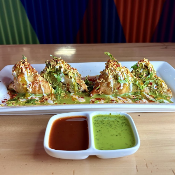 A plate of appetizers featuring various starters accompanied by a small bowl of dipping sauce for enhanced flavor.