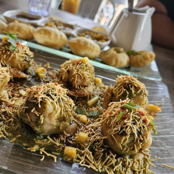  A plate featuring Chatpata Chaats, accompanied by bread and an assortment of savory Indian street snacks.