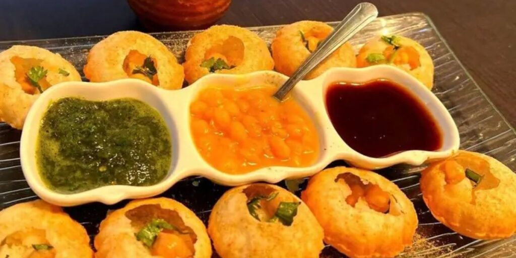 A plate featuring an assortment of Indian appetizers, including samosas, pakoras, and kebabs, perfect for wedding celebrations.