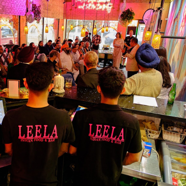 A colorful view of Leela Indian Food Bar on Gerrard Street, emphasizing its exceptional Indian dishes and friendly environment.