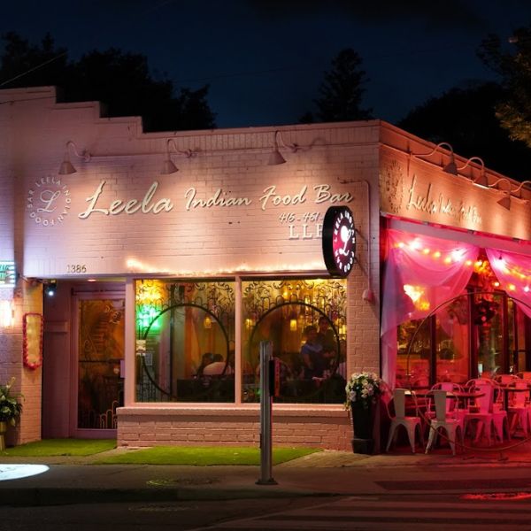 A restaurant exterior adorned with pink lights, showcasing Leela Indian Food Bar, a top Indian dining spot on Gerrard Street.